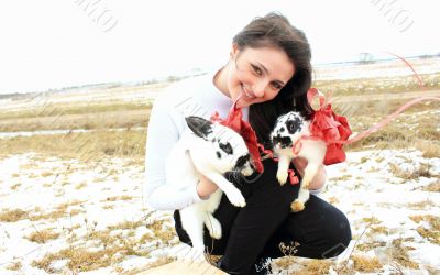 A woman holding a two rabbits