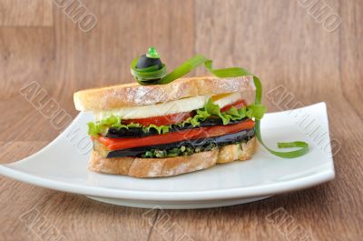 Sandwich with eggplant, tomatoes, peppers and cheese
