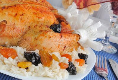 A fragment of grilled chicken with rice and dried fruit