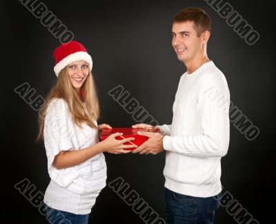 The man gives the gift pregnant girl in Santa hat