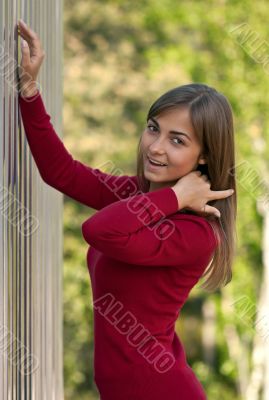 Beautiful girl in purple dress outside steel wall