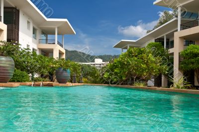 Hotel with sky-blue swimming pool with palm trees