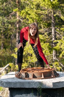 Woman tries to lift rusty manhole
