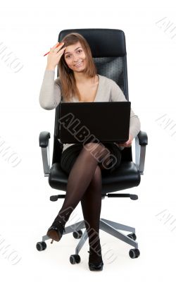Young business lady in a chair with a laptop