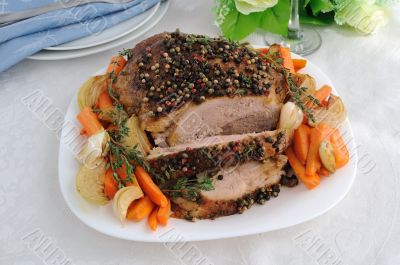 A piece of pork hams at different peppers and carrots and onions