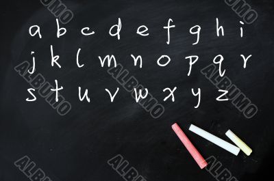 English alphabet handwritten with white chalk on a blackboard