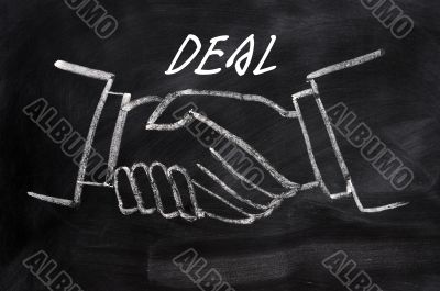 Business deal written on a blackboard background with handshaking