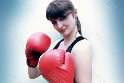 A woman stands in the boxer's gloves