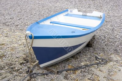 Blue and white boat on the shingle beach