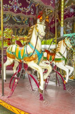 Two colourful horses in a vintage (old fashioned) carousel