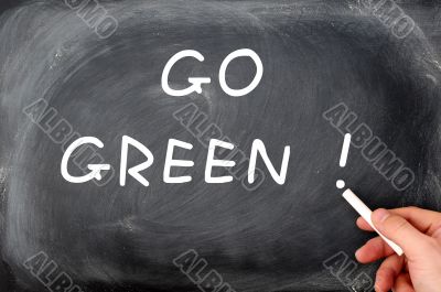 `Go Green` written on a smudged chalkboard background