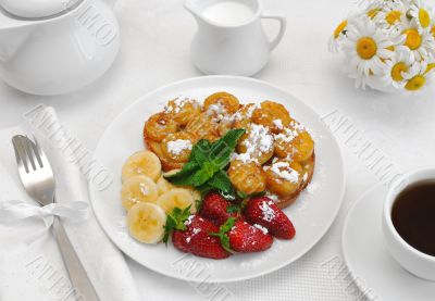 French toast with syrup and a banana with powdered sugar