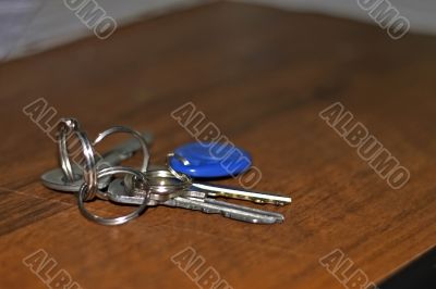 Keys with a rings lay on the brown wood table