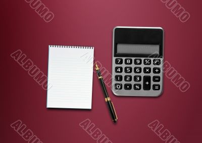 calculator, a pen and blank paper on the table 