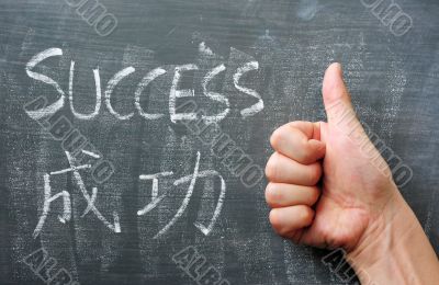 Success - word written on a blackboard with a Chinese translation