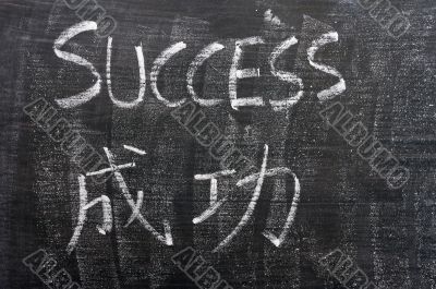 Success - word written on a blackboard with a Chinese translation