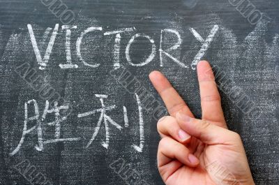 Victory - word written on a blackboard with a Chinese translation