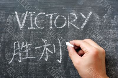 Victory - word written on a blackboard with a Chinese translation