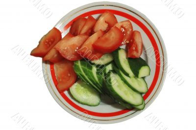 Sliced tomatoes and cocumbers on the round plate isolated