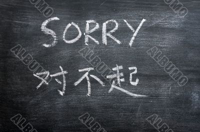 Sorry - word written on a smudged blackboard