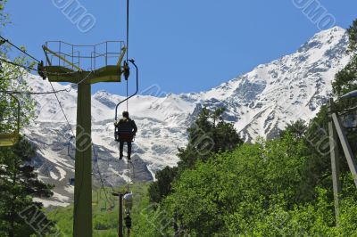 People on the chairs of cableway. Caucasian mountains