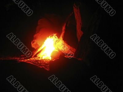 Summer night and young woman near the bonfire