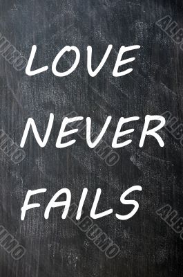 Love Never Fails written on a smudged chalkboard