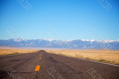 Empty freeway approaching mountains range