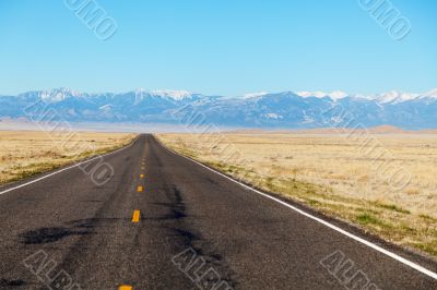 Empty freeway approaching mountains range