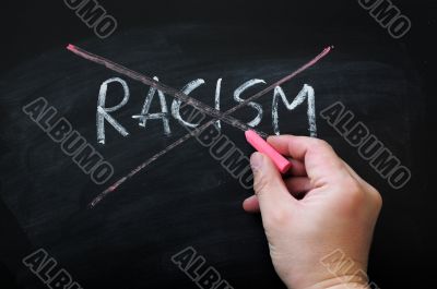Cross out racism on a smudged blackboard background