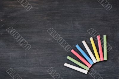 Colorful chalk on a blank smudged blackboard