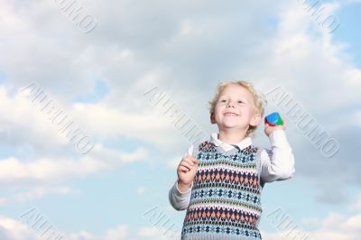 Happy little boy throwing a ball