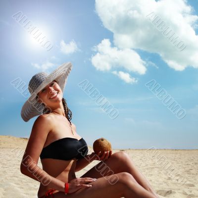 woman drinking on the beach from the coconut