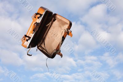 Empty suitcase on sky background