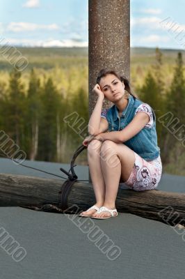 sad girl sitting on a log