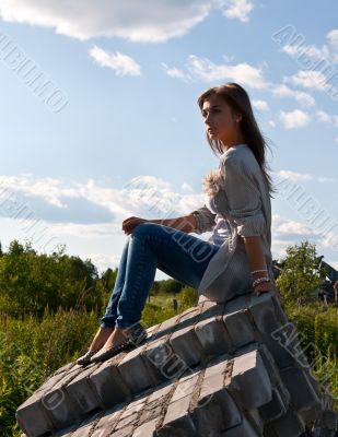 beautiful girl sitting on the ruins