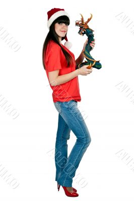 Girl in Santa hat with a decorative wooden dragon