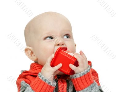 little boy chewing on a plastic pyramid in the studio
