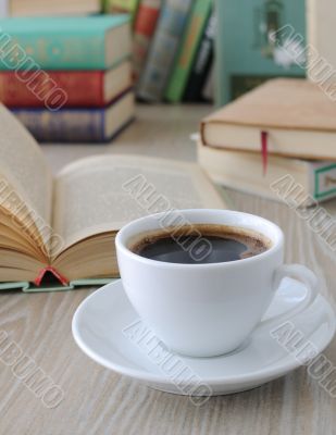 cup of coffee on a table with books	