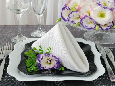 Black and white dishes served with a napkin with flowers