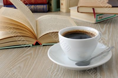 cup of coffee on a table with books	