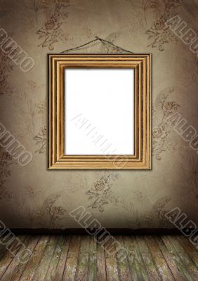Gold frame hangs on an old wall.