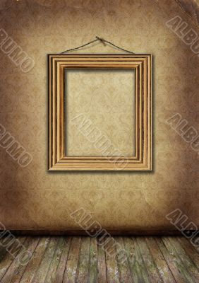 Gold frame hangs on an old wall.