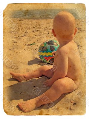 The child sits on the sand. Old postcard.