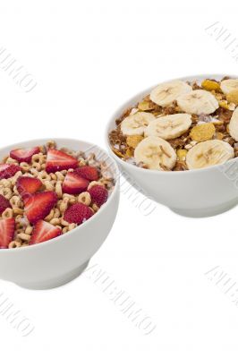 close up image of  two bowl of cereal with different fruits