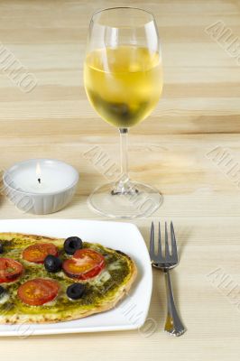 baked pizza with wineglass on table