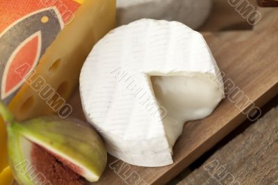 slice cheese and fig on wooden board