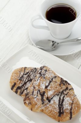 chocolate croissants on plate with cup of coffee