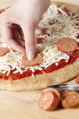 putting sausage on a pizza