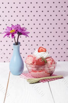 strawberry ice cream with napkin and spoon beside a flower base